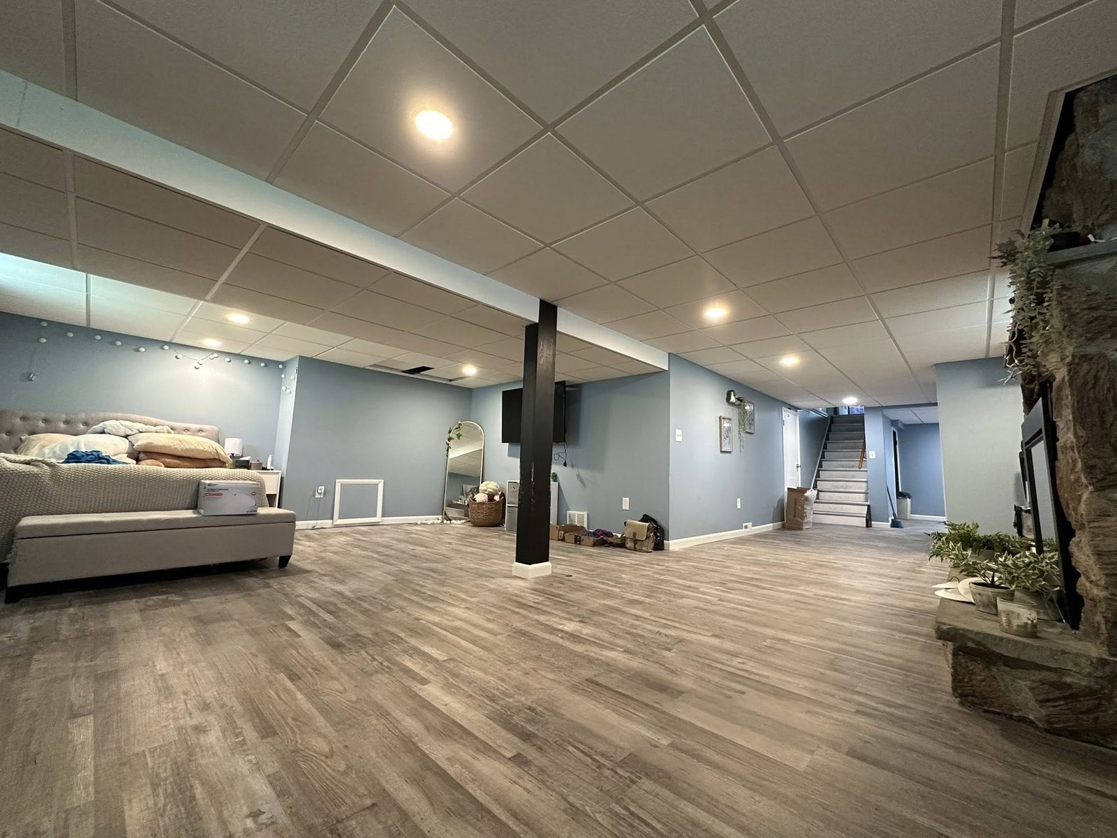 Finished basement with grey suspended ceiling and recessed lights