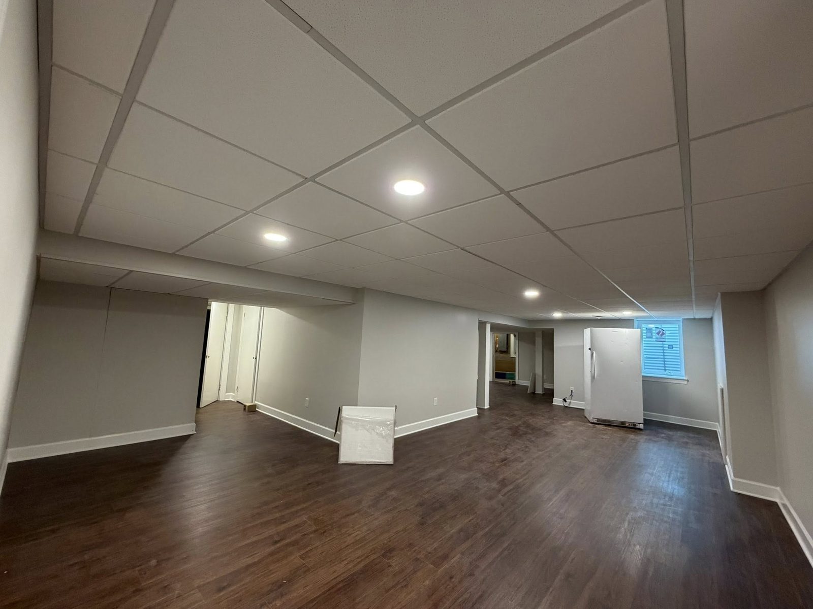 Painted suspended ceiling in a finished basement living area