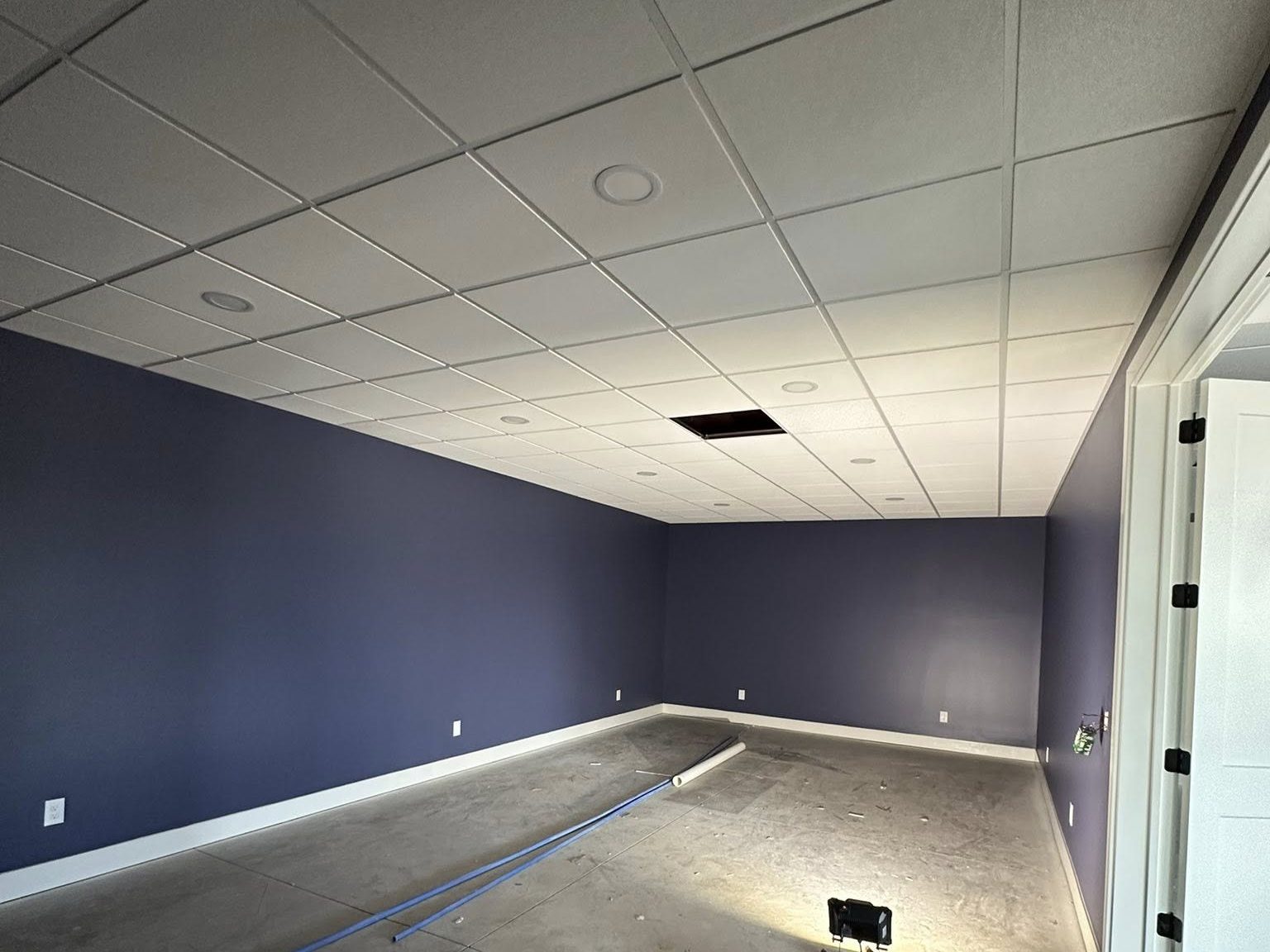 Commercial fit-out in progress with navy walls and grey suspended ceiling