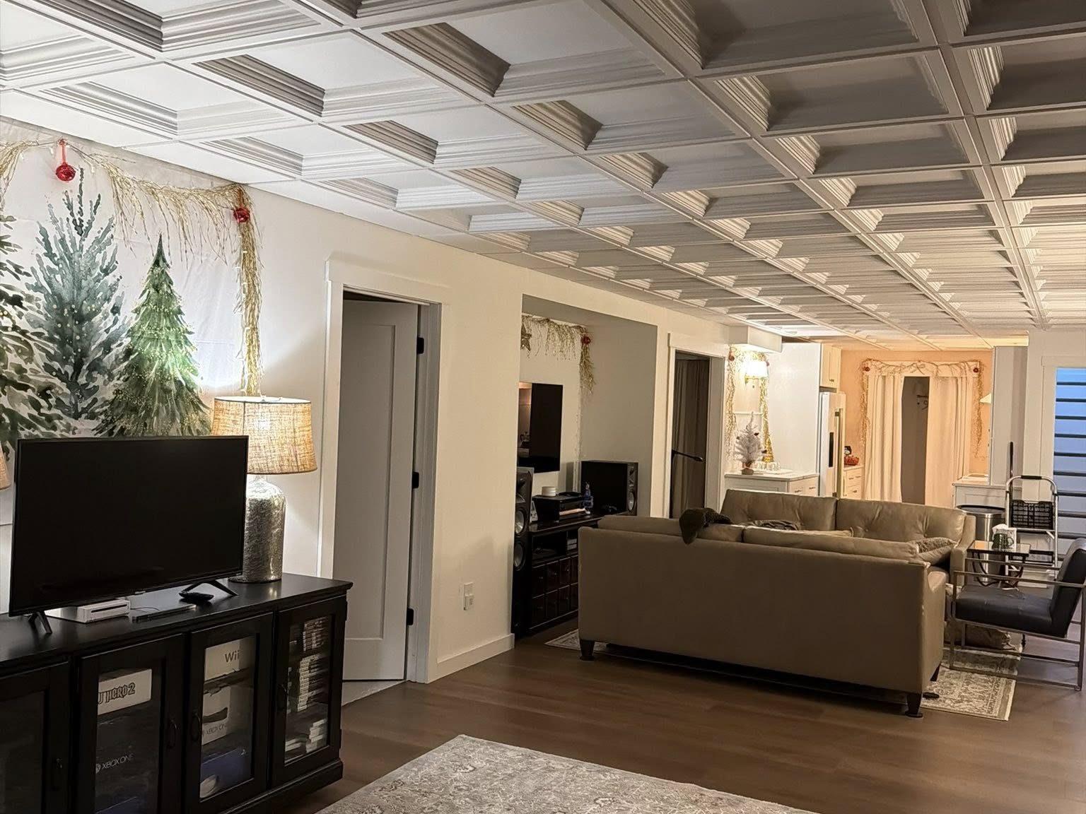 Decorative coffered drop-ceiling tiles installed across an open-plan living room and kitchen